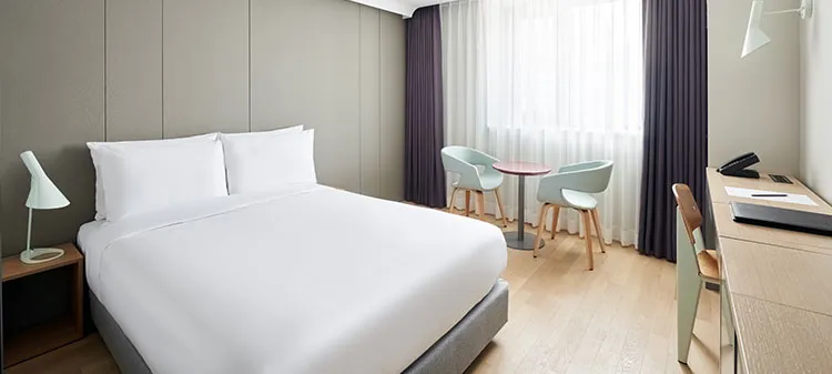 Urban Double room with a double bed, desk and two chairs by the window